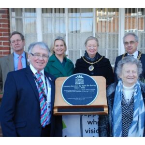 Sight for Surrey Unveils Centenary Plaque. Back row from left to right; HM-Lord Lieutenant Michael More-Molyneux, Angela Richardson, MP, Helyn Clack, Chair, Surrey County Council, Chris Hunt, Chair, Mole Valley. Front row; Bob Hughes, Chief Executive, Sight for Surrey and Cecilia Power, Chair of Trustees, Sight for Surrey.