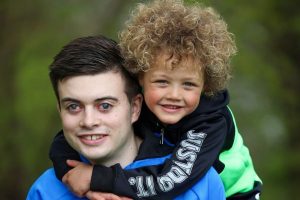 Image shows Lee Roake with his nephew, Alfie, who has his arms around Lee's shoulders, both are smiling into the camera