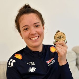 Image shows Lizzi Jordan holding a gold medal