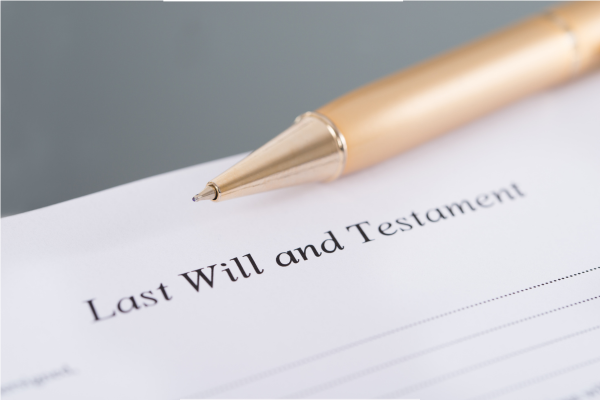 Image description: A piece of paper with the words 'Last Will and Testament' with a pen lying above the words.