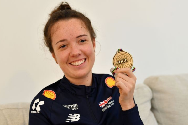 Image shows Lizzi Jordan smiling at the camera. She is holding a gold medal. Picture Credit Surrey Live