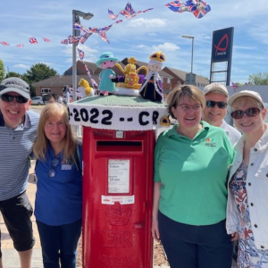 Image shows the post box and topper with Julie and Kim either side of the post box plus CYPS volunteer and local Fetcham residents.