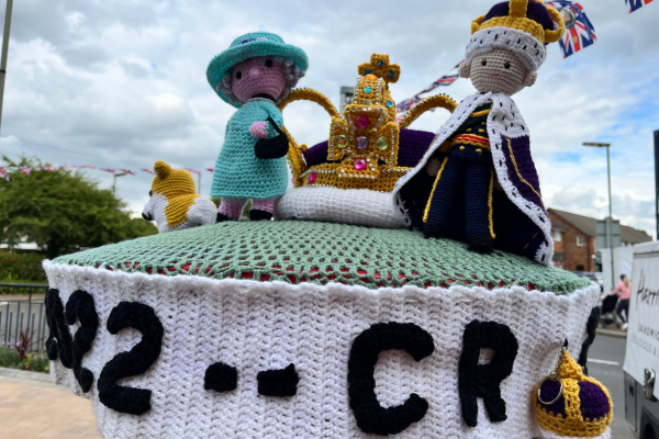 Image shows the crocheted post box topper with The Queen and King and the Coronation Crown.