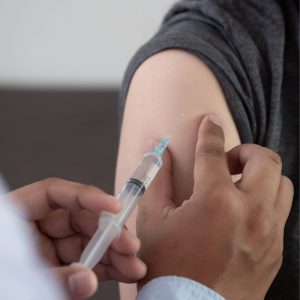 An injection about to be administered into an arm.