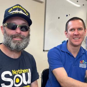 An attendee to Meet Up Catch is sitting next to a member of staff from the charity.