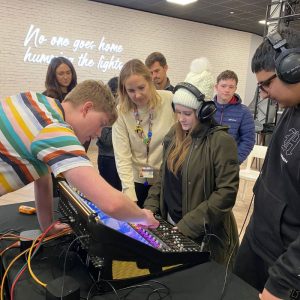 A young girl is testing out the vision mixing console.