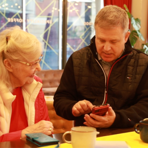 Keith showing a lady how to use a screen reader on her mobile phone 