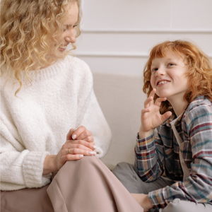 A woman and child are sitting next to each other chatting 