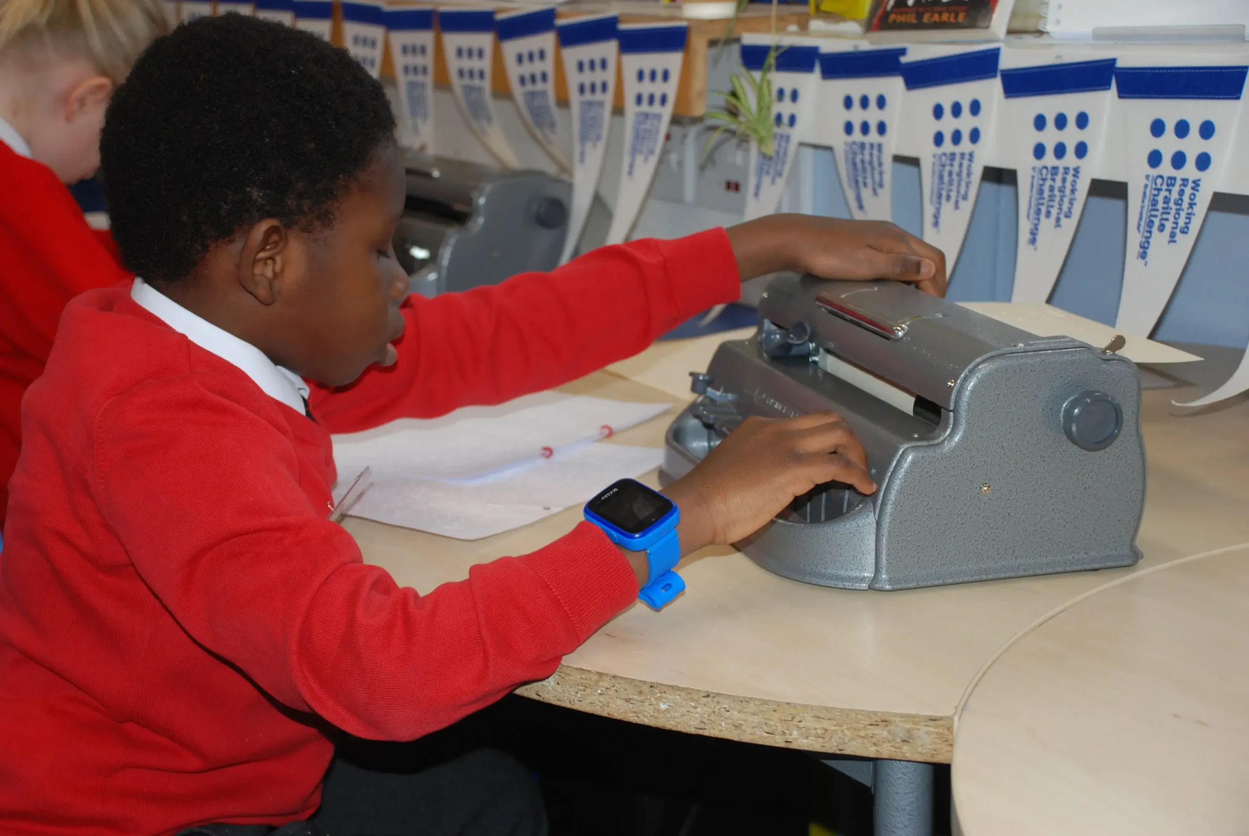 A young boy using a braille machine