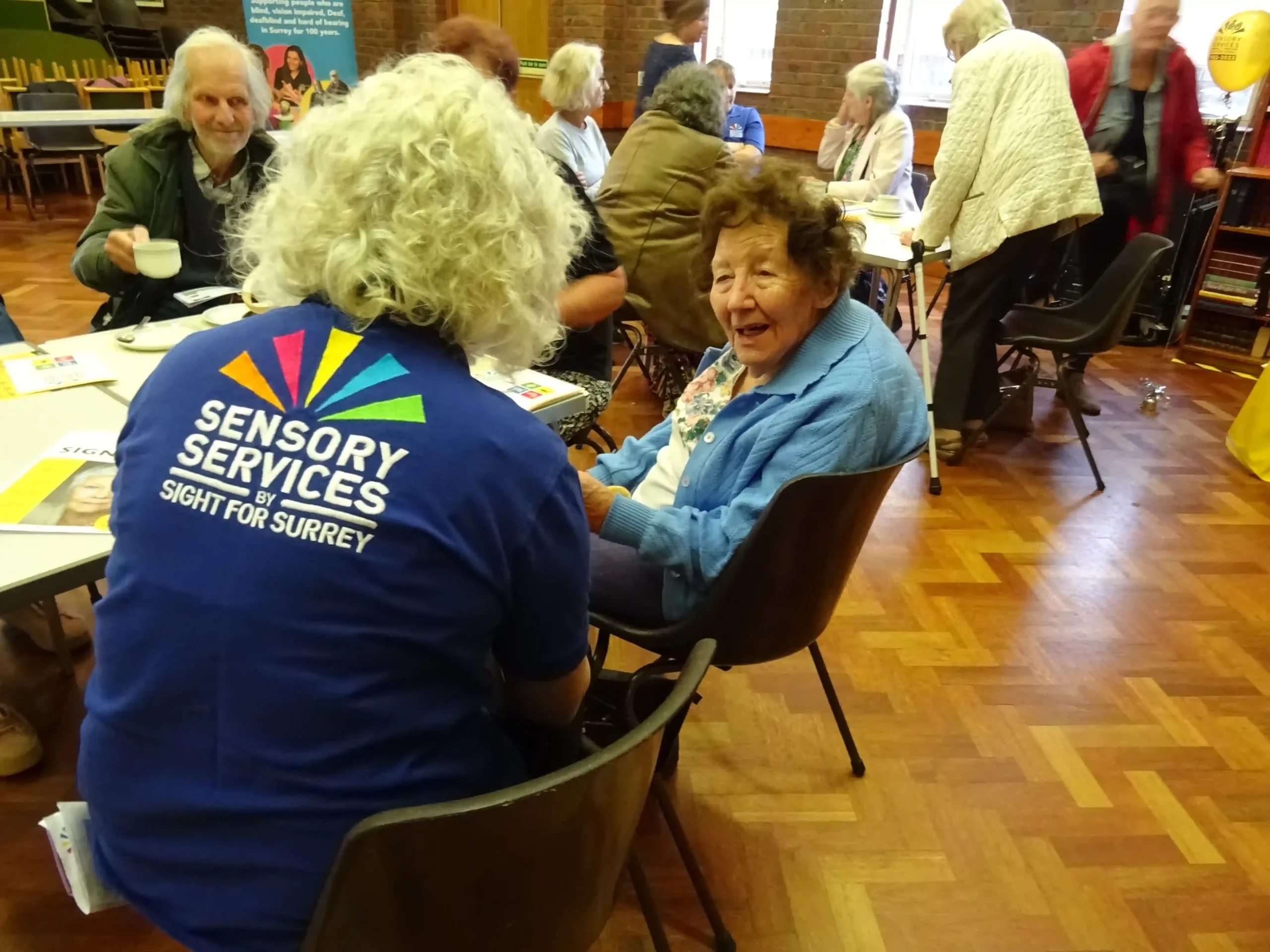 A member of staff talking to an elderly lady.