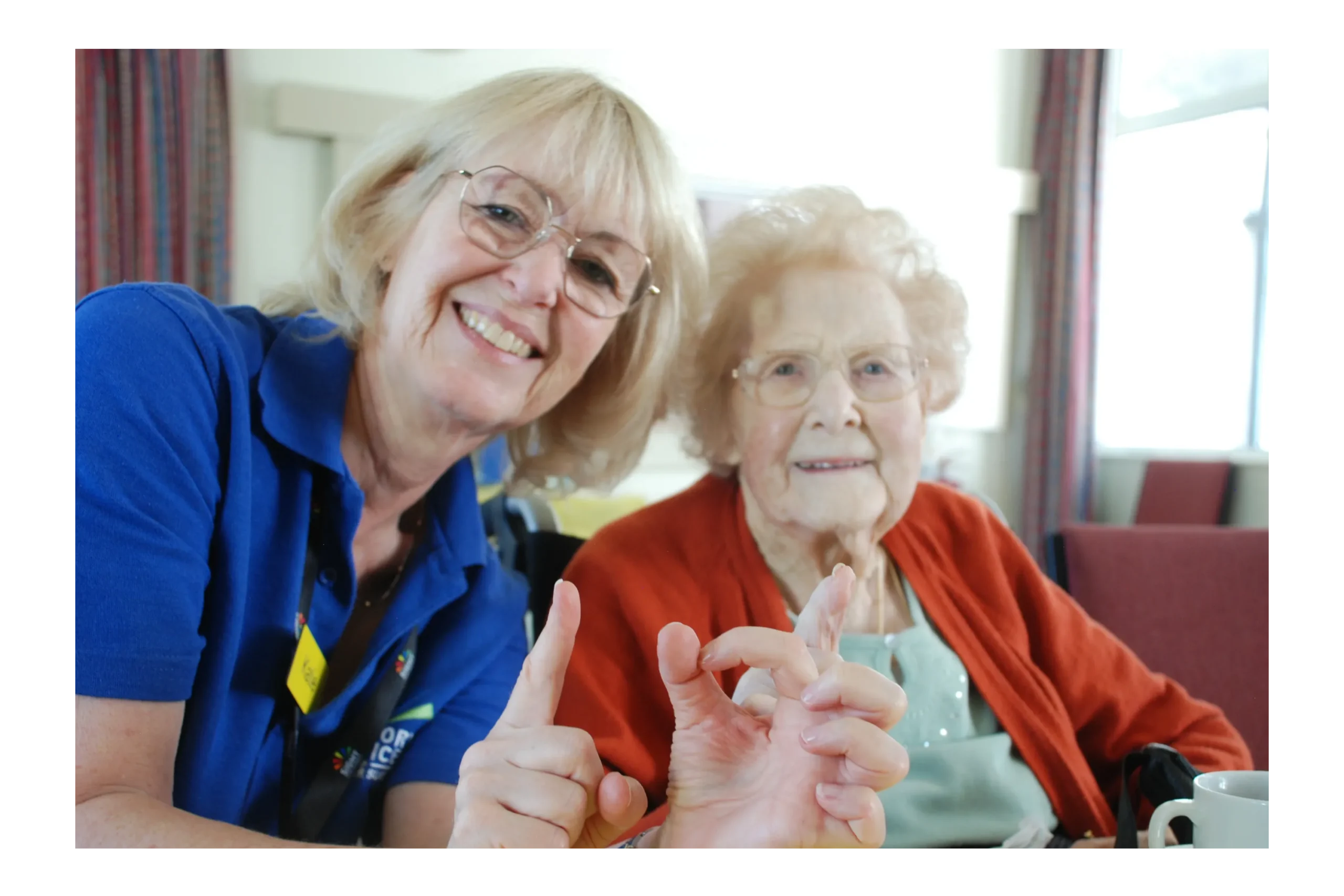 A member of staff with an elderly lady supported by the charity.