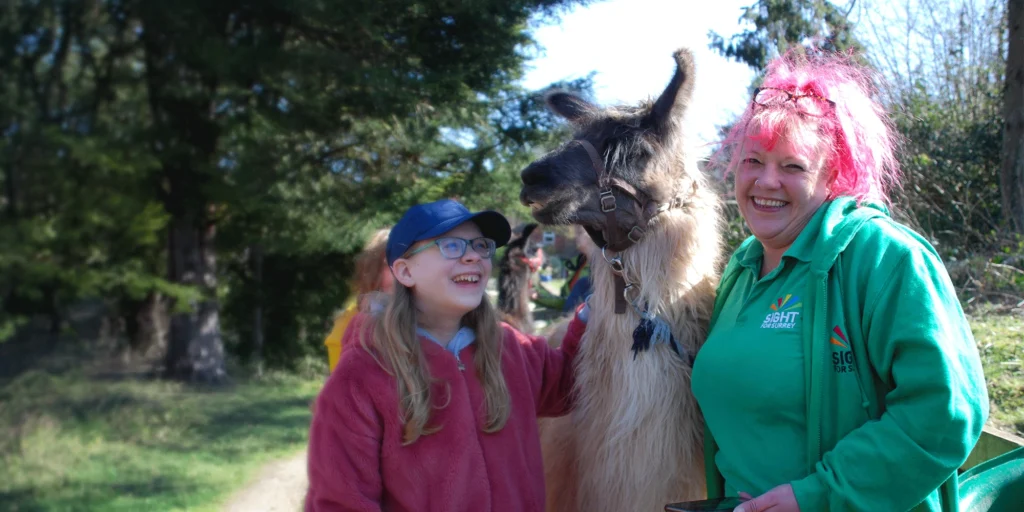 Fi from the children's team with a young girl we support, between them is a llama.
