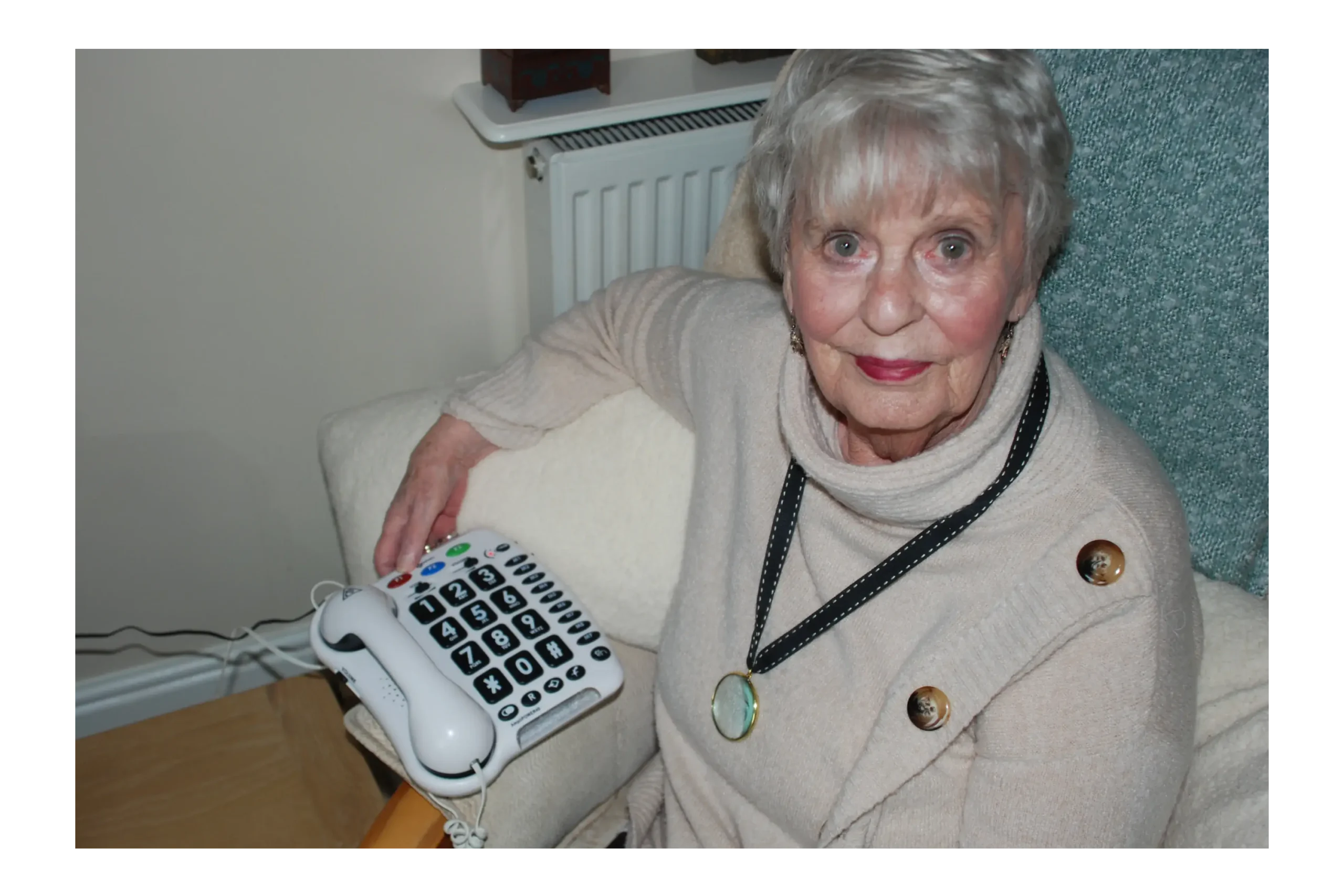 A lady using a large button phone.
