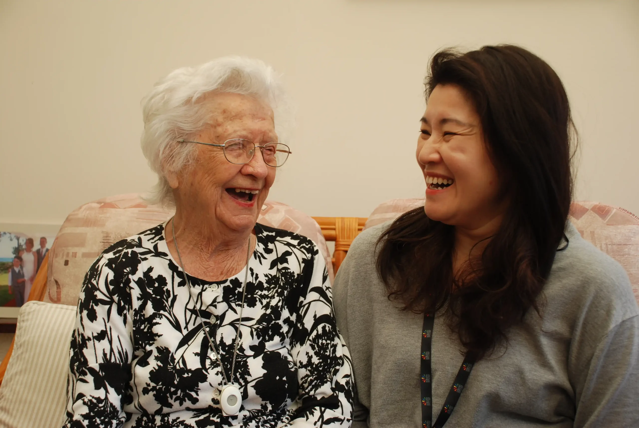 Doris who is supported by the charity sharing a joke with Jessie, a volunteer home visitor