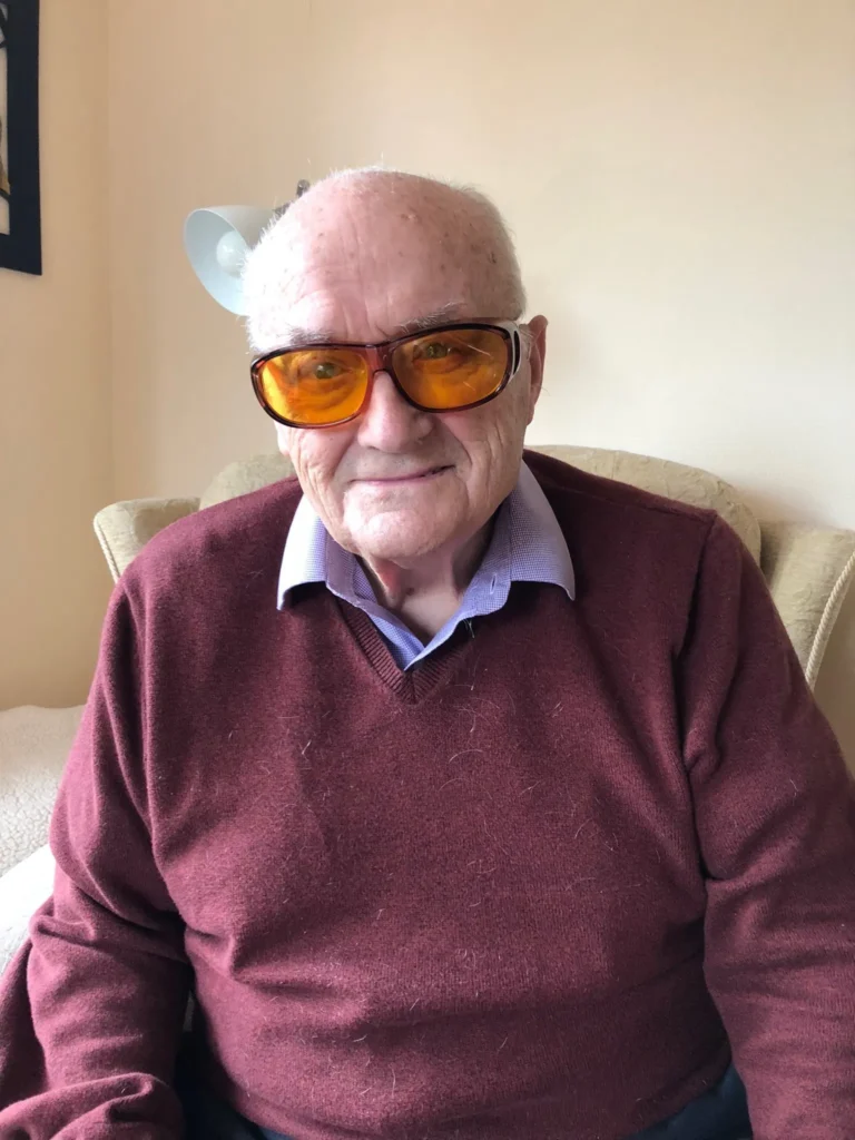 Brian wearing a pair of yellow tinted glasses that the charity provided.