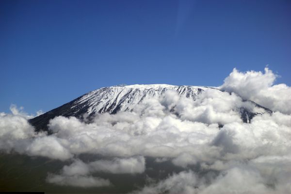 Mount Kilimanjaro surrounded by clouds around its base