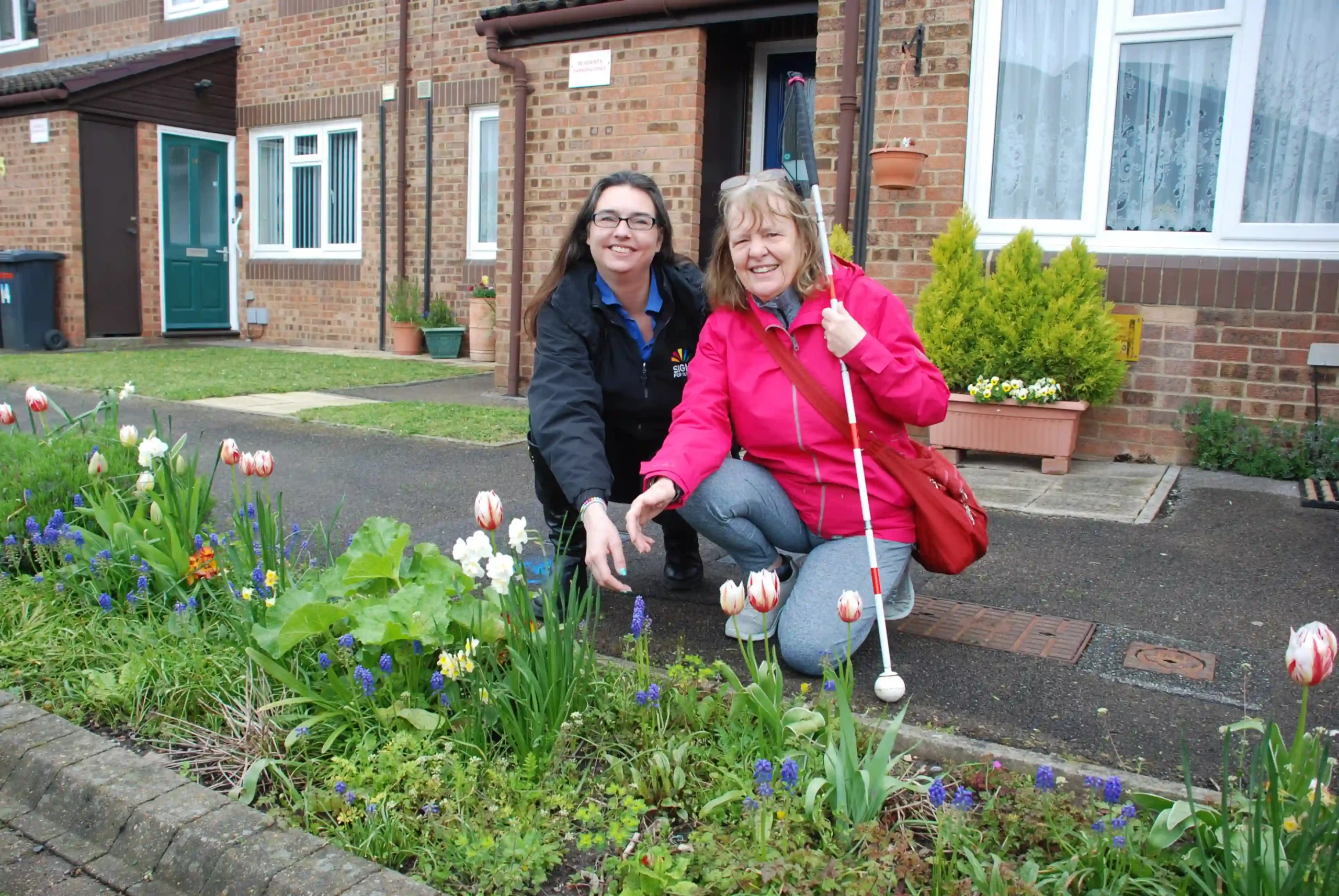 Suzie, Communicator Guide, with Larraine showing off their handy-work in the garden.