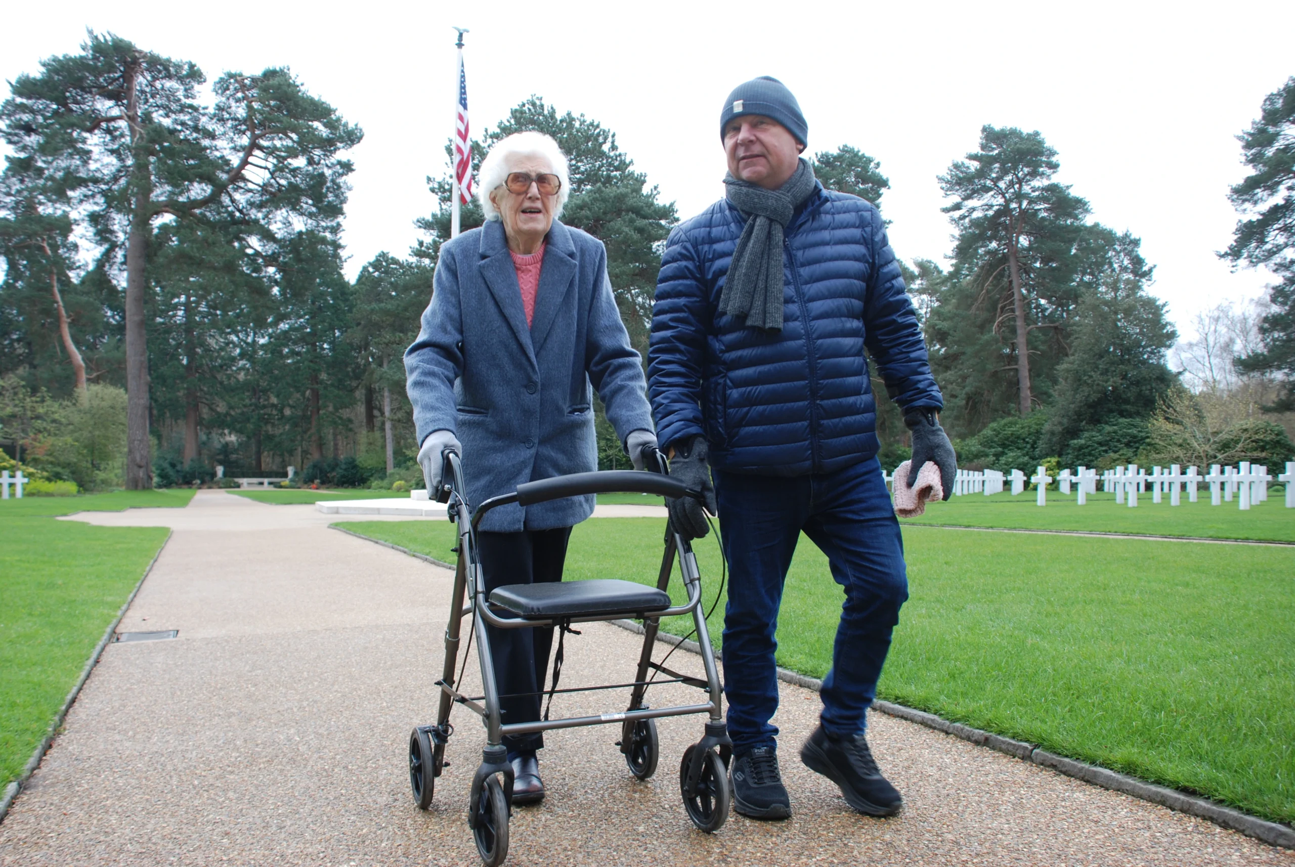Communicator Guide, Tony, walking through Brookwood Military Cemetery with Val, a lady with hearing and sight loss, that he supports weekly.