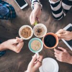 People holding tea and coffee in mugs