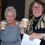 Two people holding coffee cups and smiling