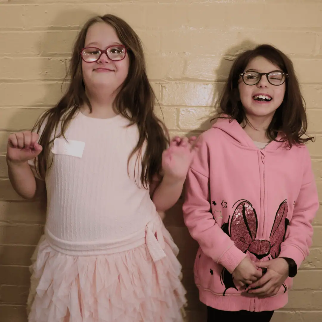 Two girls dressed in pink wearing glasses