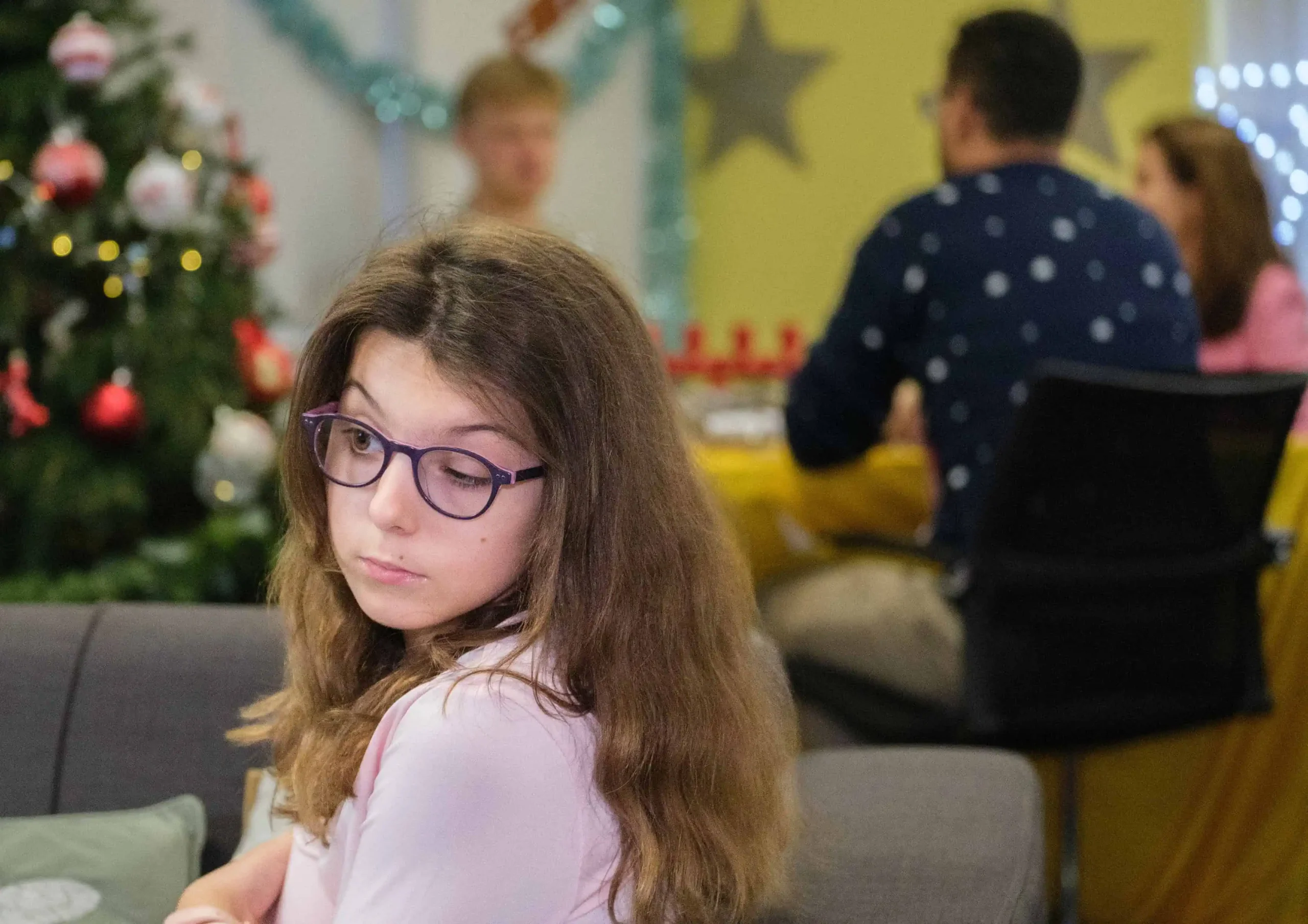 Girl with glasses in front of a Christmas tree