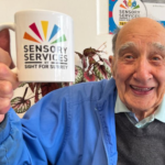 Reg an attendee is our Community Hub holding a mug of tea